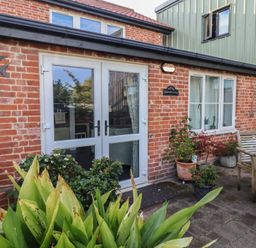 A patio with plants and a door at Blacksmith's Cottage in Ipswich