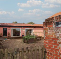 An outdoor area with games room sign and seating at Blacksmith's Cottage in Ipswich