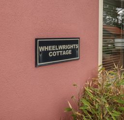 A nameplate for Wheelwright's Cottage at the exterior of a building in Ipswich