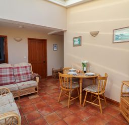 A dining room with a sofa and a table at Wheelwright's Cottage in Ipswich