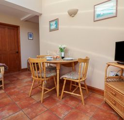 A dining room with a table and chairs at Wheelwright's Cottage in Ipswich