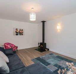 A living room with a fireplace and sofa at 3 The Stables in Highbridge
