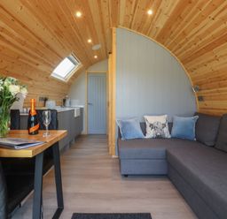 A living room with a kitchenette and a sofa at Barley near Nelson