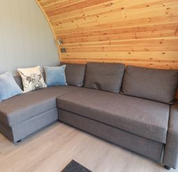 A living room with a gray sofa and cushions at Barley near Nelson