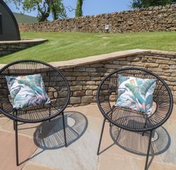 Two black chairs with decorative pillows on a patio at Black Moss Nelson