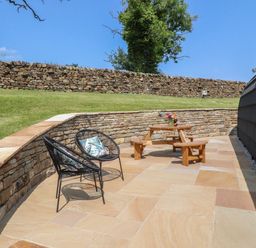 An outdoor area with seating and a stone wall at Ogden in Nelson