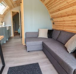 A living room with a couch and kitchenette at Ogden in Nelson
