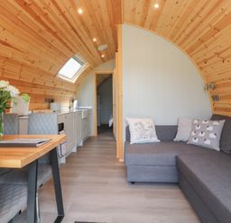 A living room with a kitchen area and dining table at Pendle in Nelson