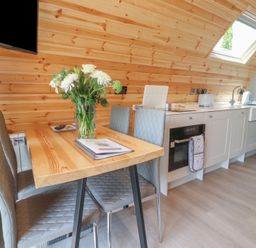 A kitchen with a table and chairs and a television at Pendle in Nelson