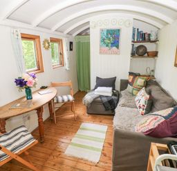 A living room with a sofa and table at The Shephard Hut near Solva