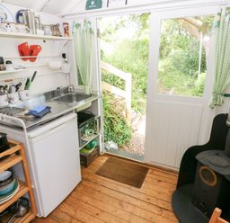 A kitchen with a sink and fridge at The Shephard Hut Nine Wells near Solva