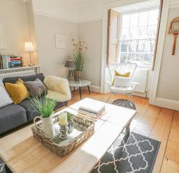 A living room with a sofa and books on a shelf at Bwthyn Morse in Llanfair