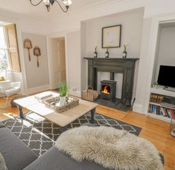 A living room with a fireplace and coffee table at Bwthyn Morse Llanfair