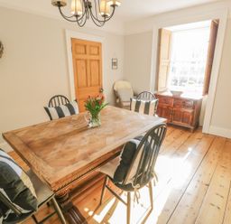 A dining room with a table and chairs at Bwthyn Morse Llanfair
