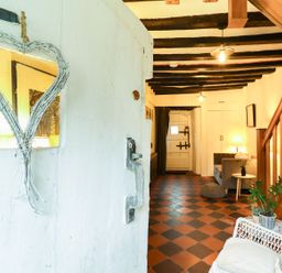 A hallway with a mirror and sofa at Bwthyn Canol in Llanfair