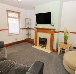 A living room with a fireplace and television at Bolton Terrace in Workington