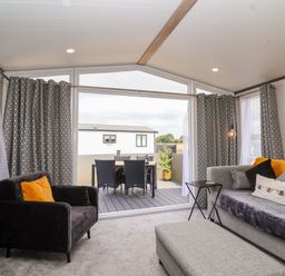 A living room with a sofa and television at Hazelnut Lodge in Chipping Norton