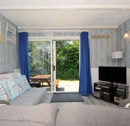 A snug with a sofa and a tv at 8 Hillside in Bude