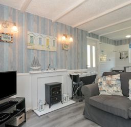 A living room with a sofa and television at 8 Hillside in Bude