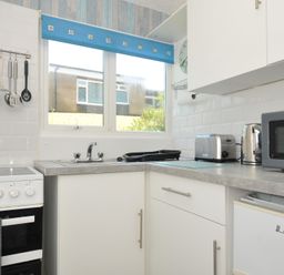 A kitchen with stove, sink and appliances at 8 Hillside in Bude