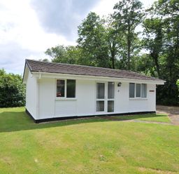 A bungalow with a front door and windows at 4 Rosecraddoc Lodge Holiday Bungalows in Liskeard