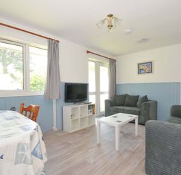 A living room with a table and chairs and a tv at 4 Rosecraddoc Lodge Holiday Bungalows in Liskeard