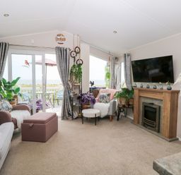 A living room with a sofa, television, and fireplace at No. 2 - Seaview in Kessingland