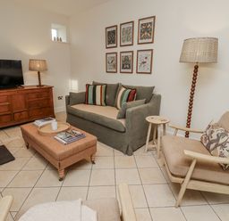A living room with furniture and decor at Watermill Cottage in North Charlton