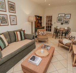 A living room with a sofa and coffee table at Watermill Cottage North Charlton