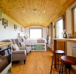 A living room with a kitchen unit and seating area at Defaid Cymreig Oswestry