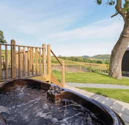 An outdoor area with a hot tub and decking at Cheviot in Oswestry