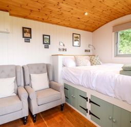 A bedroom with a bed and armchairs at Cheviot in Oswestry