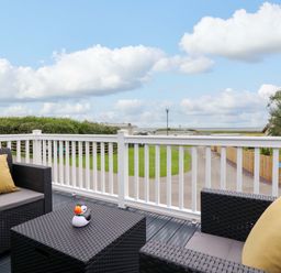 A deck with furniture and a view at 8 Puffin Way Llwyngwril