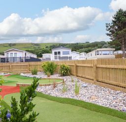 An outdoor area with caravans and landscaped garden at 8 Puffin Way Llwyngwril