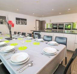 A dining room with a long table set for a meal at Silver Copse Frilford Heath Near Abingdon
