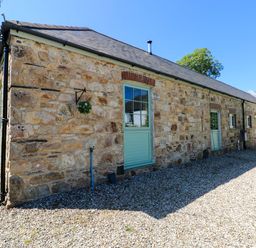 An exterior view of a stone building with a green door at Carreg Las Haverfordwest