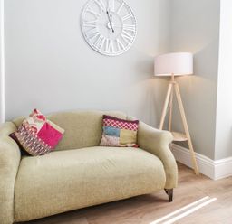 A living room with a sofa and lamp at Flat 1A, Mona House in Conwy