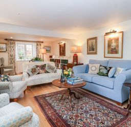 A living room with a sofa and armchair at Magdalen Cottage in Hook Norton