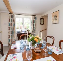 A dining room with a table and chairs at Magdalen Cottage in Hook Norton