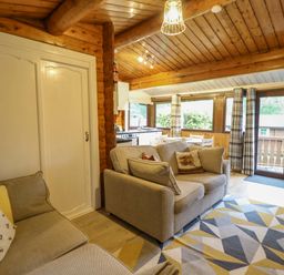 A living room with a sofa and table at Swn Yr Afon - No 333