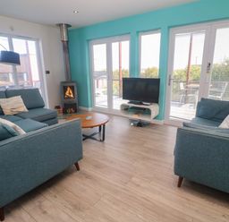 A living room with a sofa and coffee table at Lodge 83, Gwel an Mor, Portreath