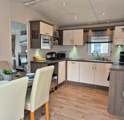 A kitchen with dining table and appliances at Fernwood Lodge in Fritton near Belton Norfolk