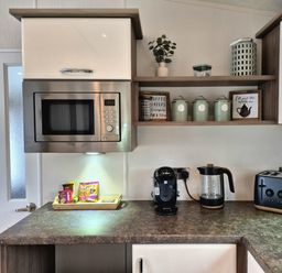 A kitchen with microwave, coffee maker, kettle and toast at Fernwood Lodge in Fritton near Belton, Norfolk