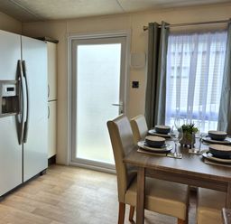 A kitchen with a table set for dining at Fernwood Lodge in Fritton near Belton, Norfolk