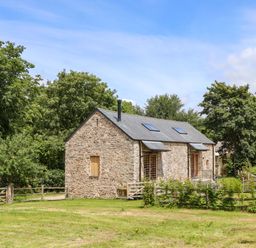 A stone house with a grassy area at Lower Walreddon Barn Tavistock