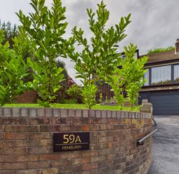 A house with plants and a driveway at 59A Pemburry