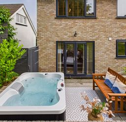 A garden with a hot tub and outdoor seating at 59a Gwscwm Road