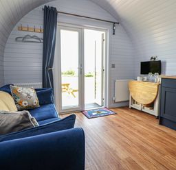 A living room with a sofa and television at Honeypot Hideaways - Manuka