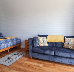 A bedroom with a bed and sofa at Honeypot Hideaways - Clover