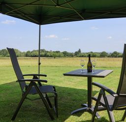 A seating area with a table and drinks under a tent at Honeypot Hideaways - Clover